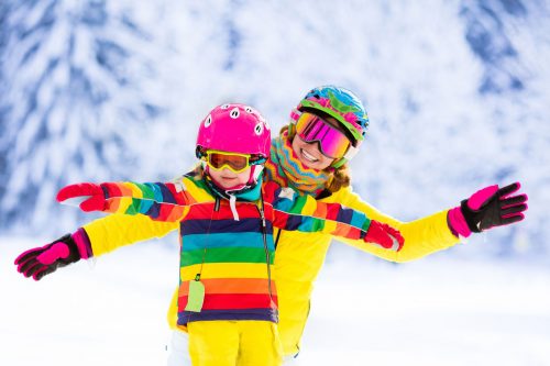 51422057 - mother and little child skiing in alps mountains. active mom and toddler kid with safety helmet, goggles and poles. ski lesson for young children. winter sport for family. little skier racing in snow